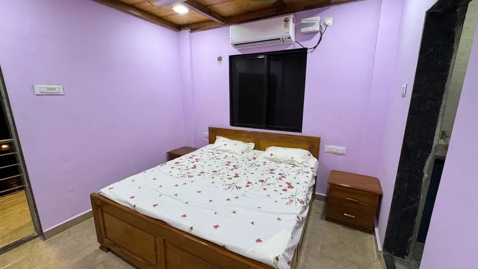 Lilac bedroom with a wooden bed, a bedside table and a window