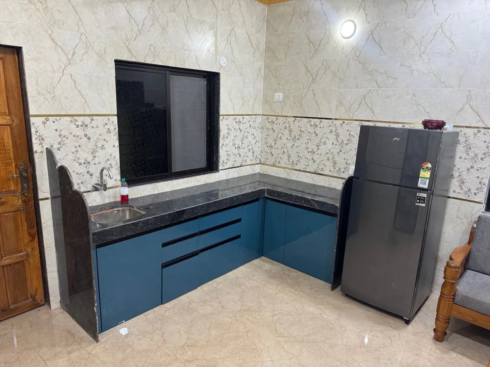 Kitchen counter with a sink and blue cabinets, next to a refrigerator